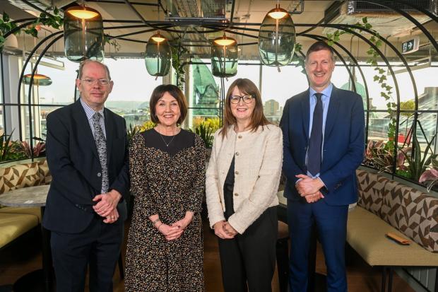 The Chair of the Fiscal Council, Sir Robert Chote, standing with fellow Council Members, Dr Esmond Birnie and Maureen O'Reilly with Minister of Finance Dr Archibald